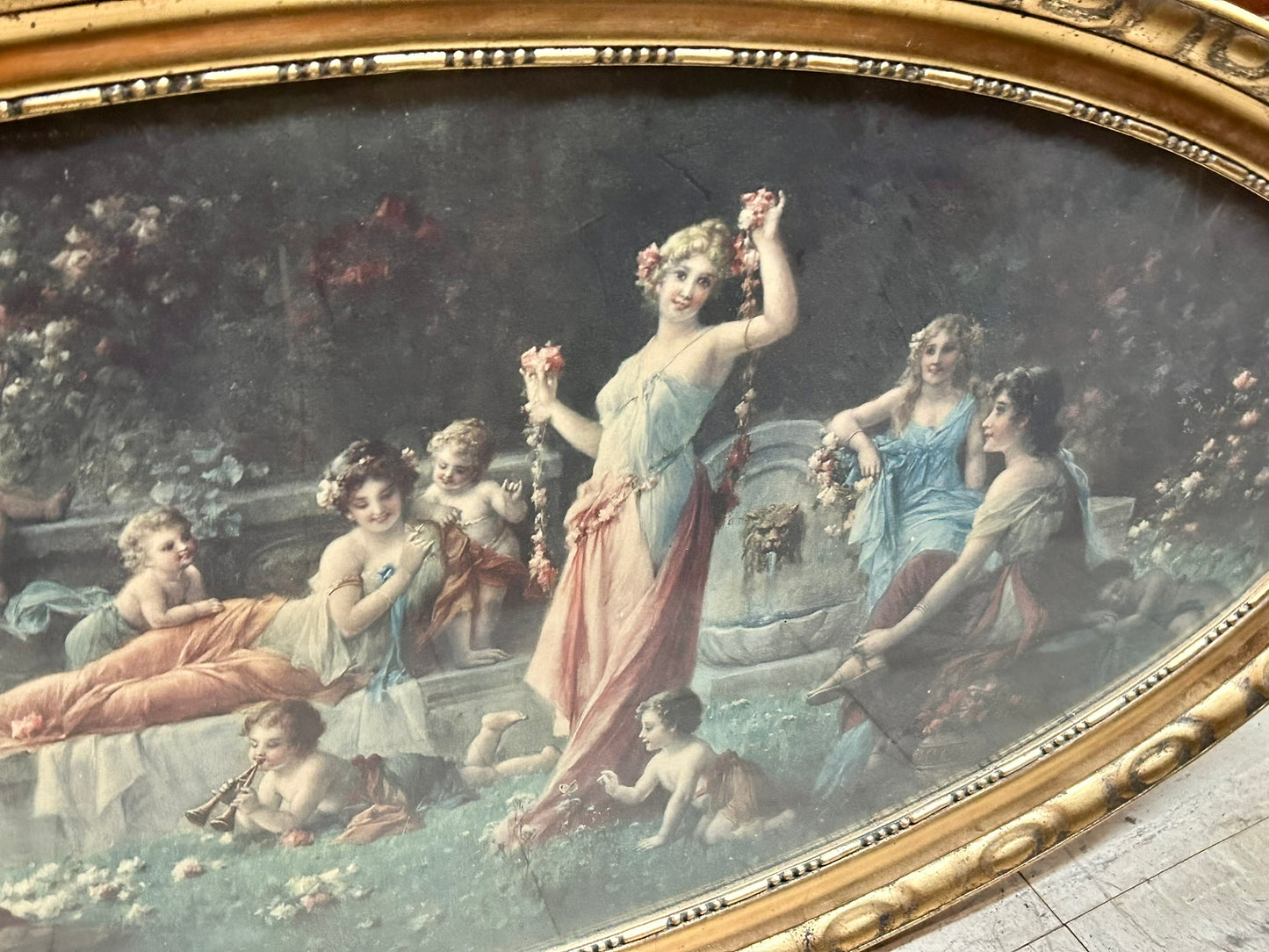 LARGE EARLY 1900'S OVAL PICTURE OF CLASSICAL LADIES AND CHILDREN FROLICKING IN FLOWER GARDEN