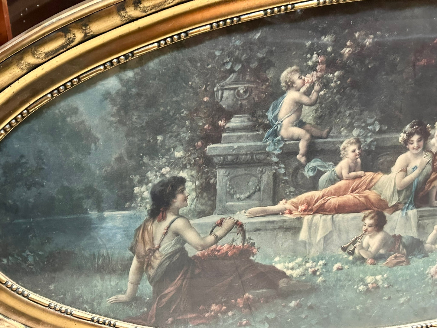 LARGE EARLY 1900'S OVAL PICTURE OF CLASSICAL LADIES AND CHILDREN FROLICKING IN FLOWER GARDEN