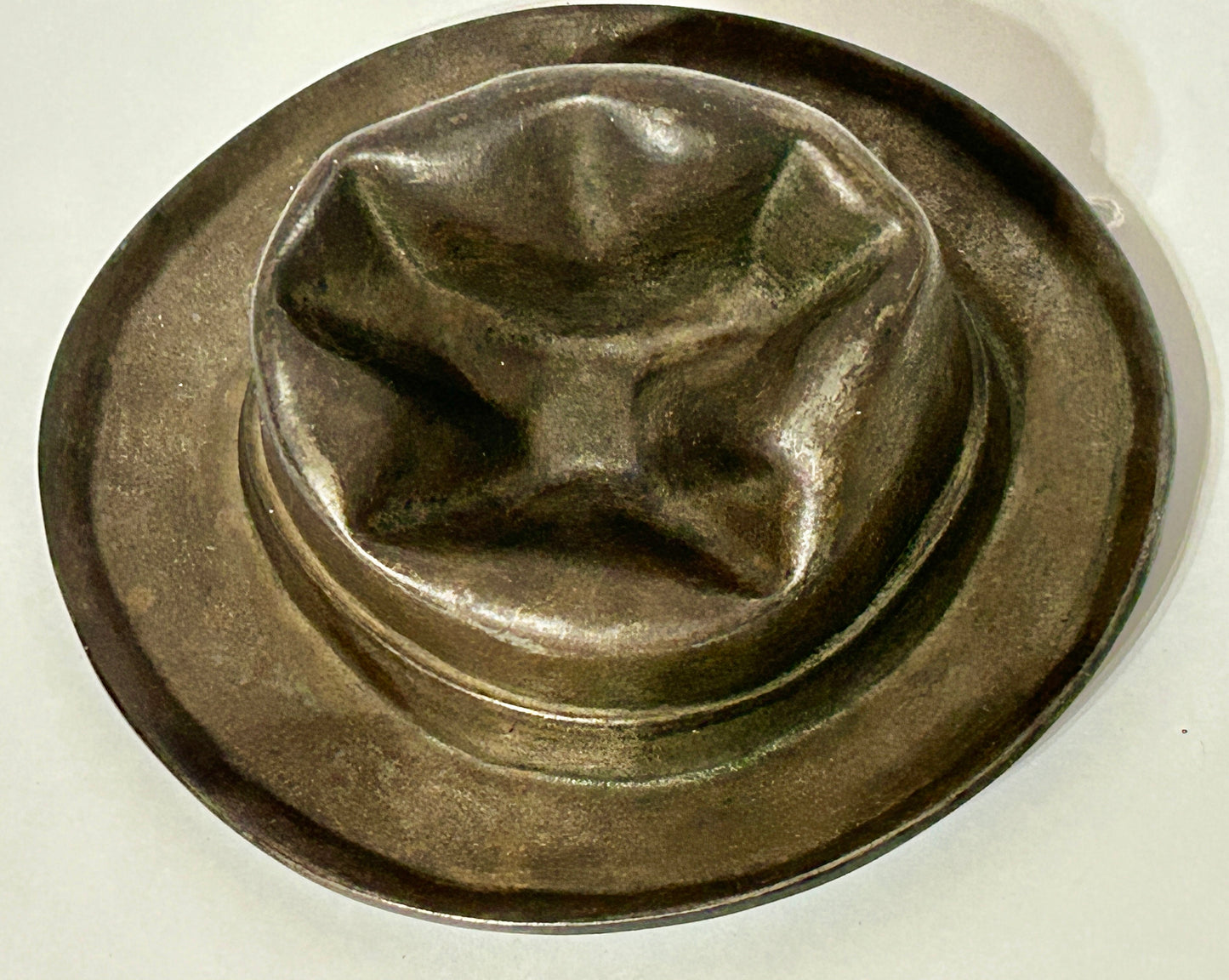 ANTIQUE CAST IRON HAT WITH SMASHED LOOK TOP