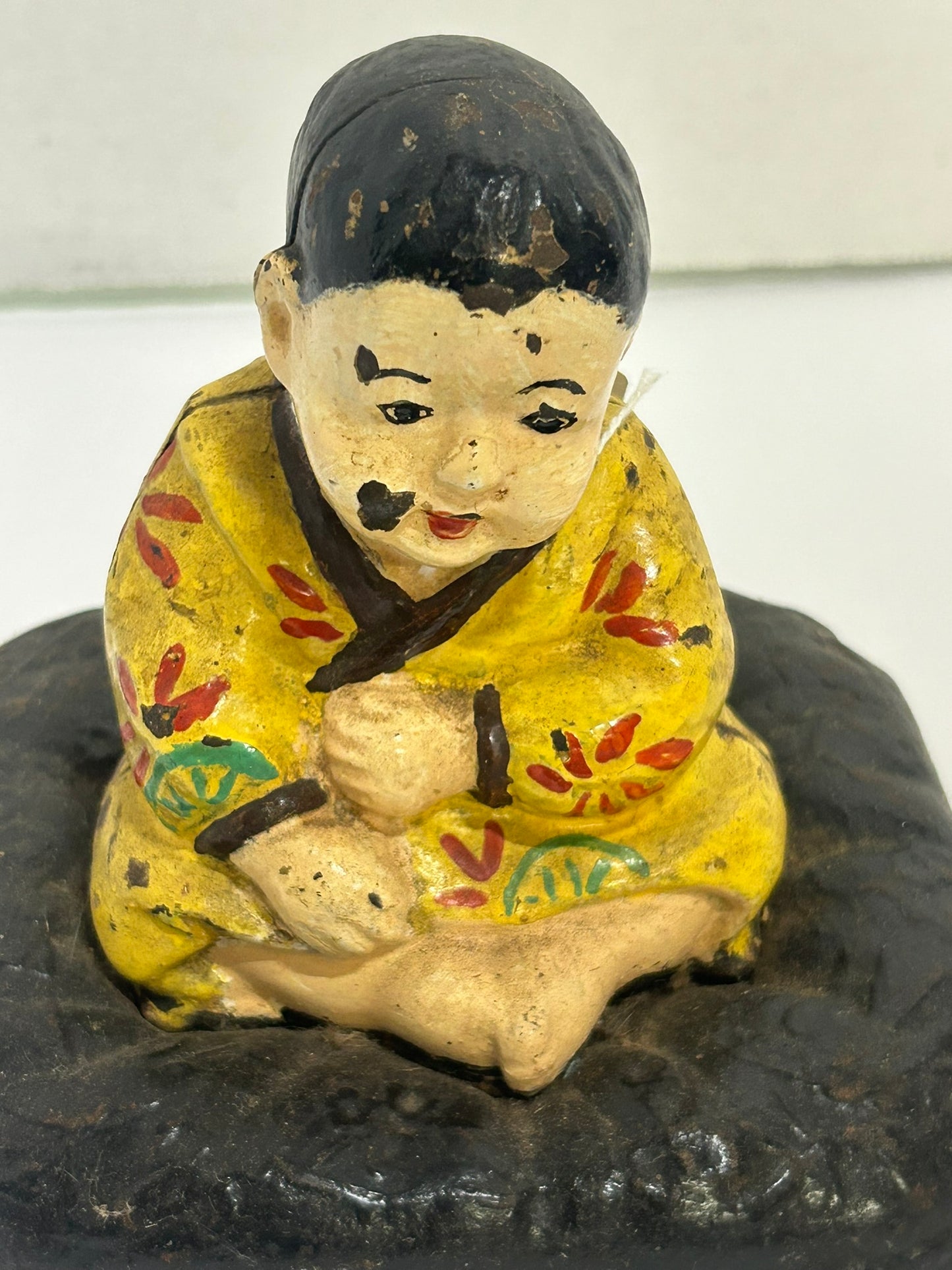 ANTIQUE CAST IRON DOORSTOP OF TAKEO ON CUSHION