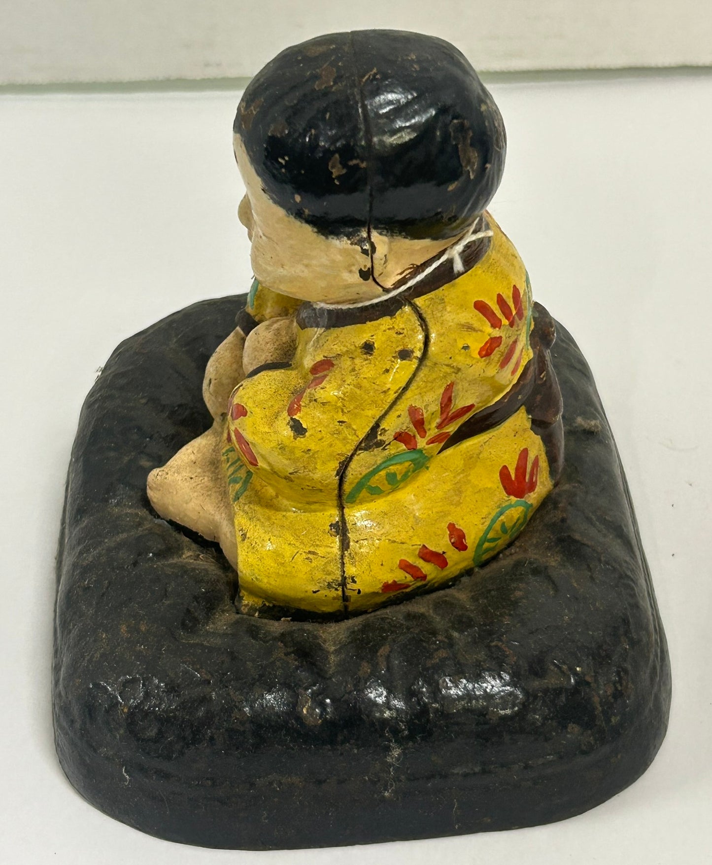 ANTIQUE CAST IRON DOORSTOP OF TAKEO ON CUSHION