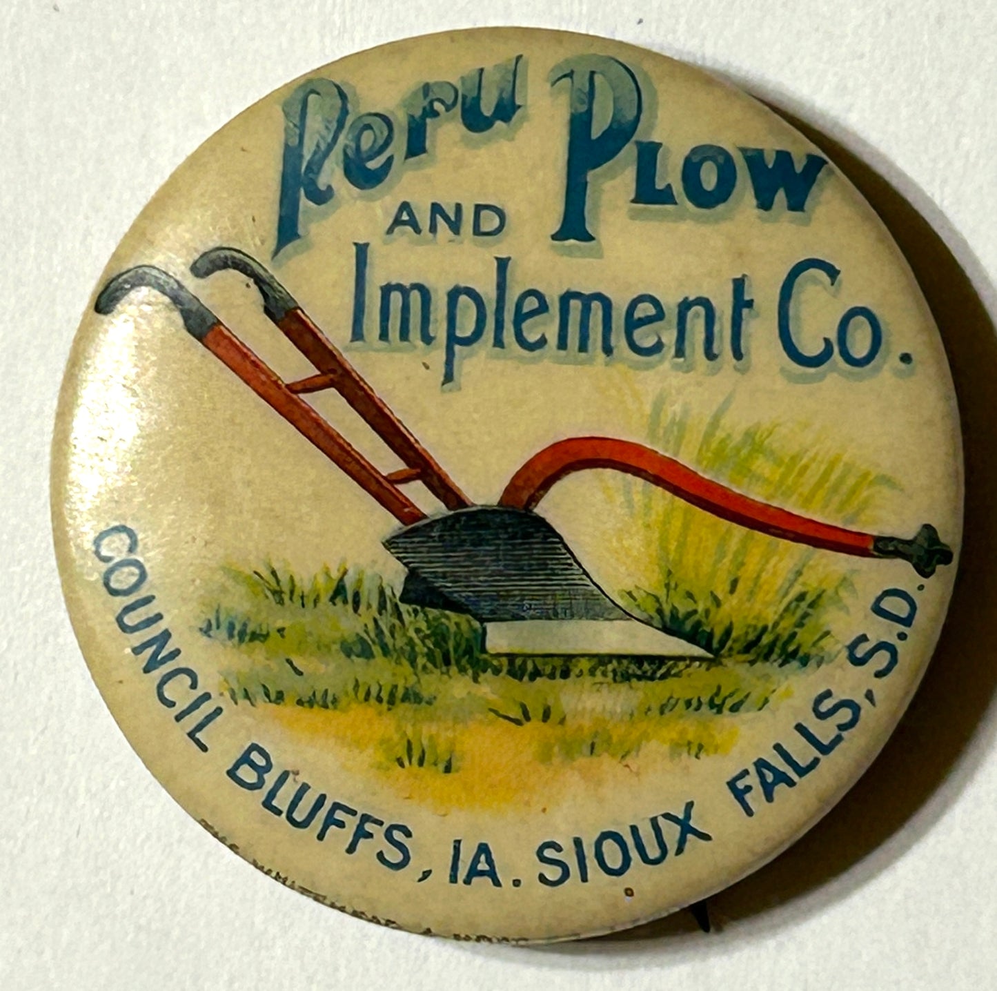 PERU PLOW AND IMPLEMENT CO. OF COUNCIL BLUFFS IOWA AND SIOUX FALLS SOUTH DAKOTA ANTIQUE PINBACK ADVERTISING BUTTON
