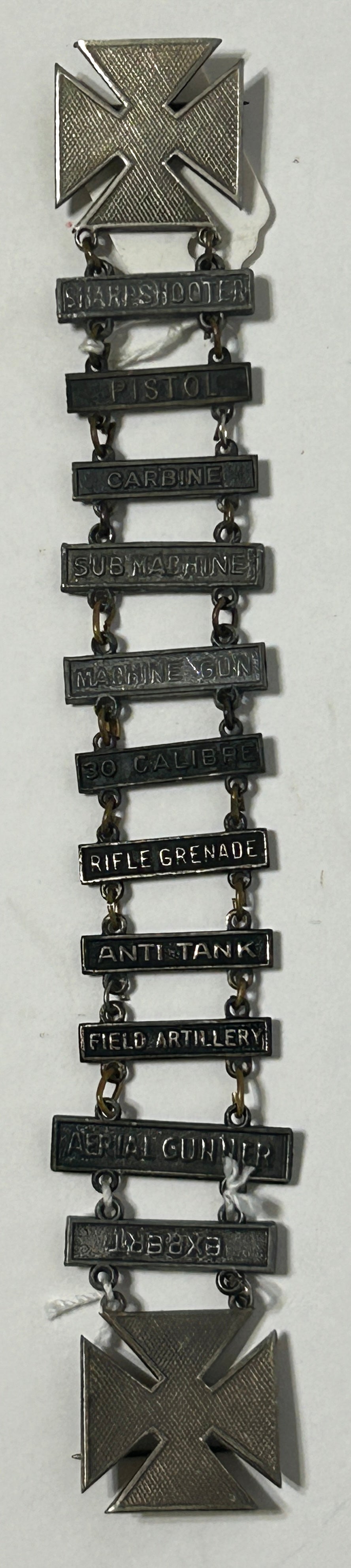 UNITED STATES MILITARY MARKSMAN LADDER BADGE WITH ELEVEN DIFFERENT QUALIFACATIONS