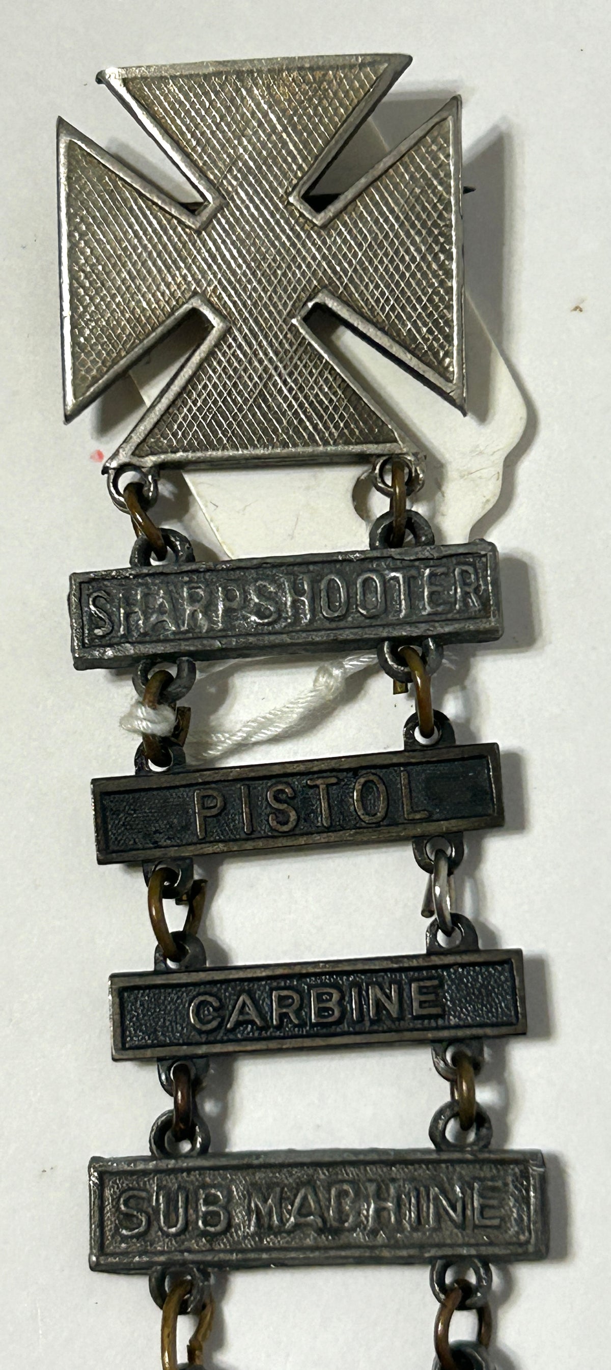 UNITED STATES MILITARY MARKSMAN LADDER BADGE WITH ELEVEN DIFFERENT QUALIFACATIONS
