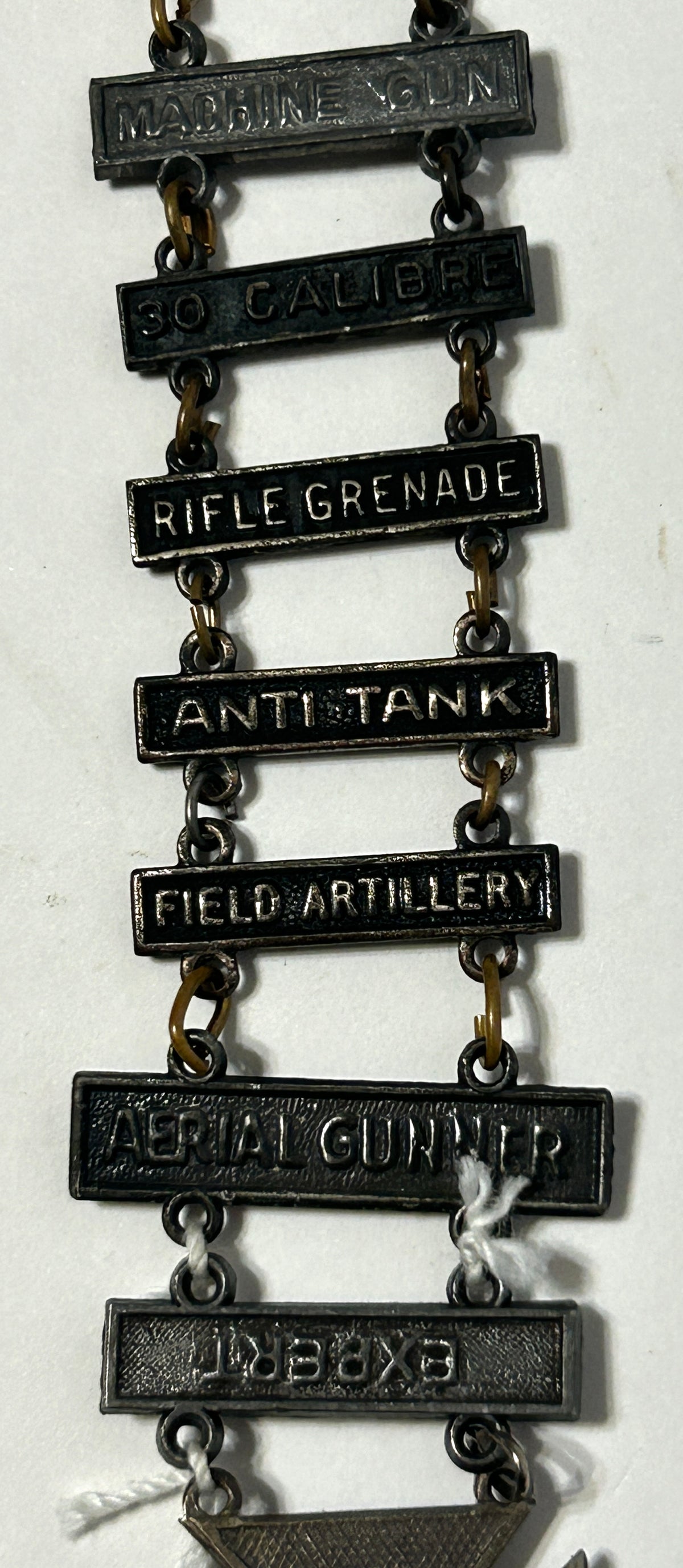 UNITED STATES MILITARY MARKSMAN LADDER BADGE WITH ELEVEN DIFFERENT QUALIFACATIONS